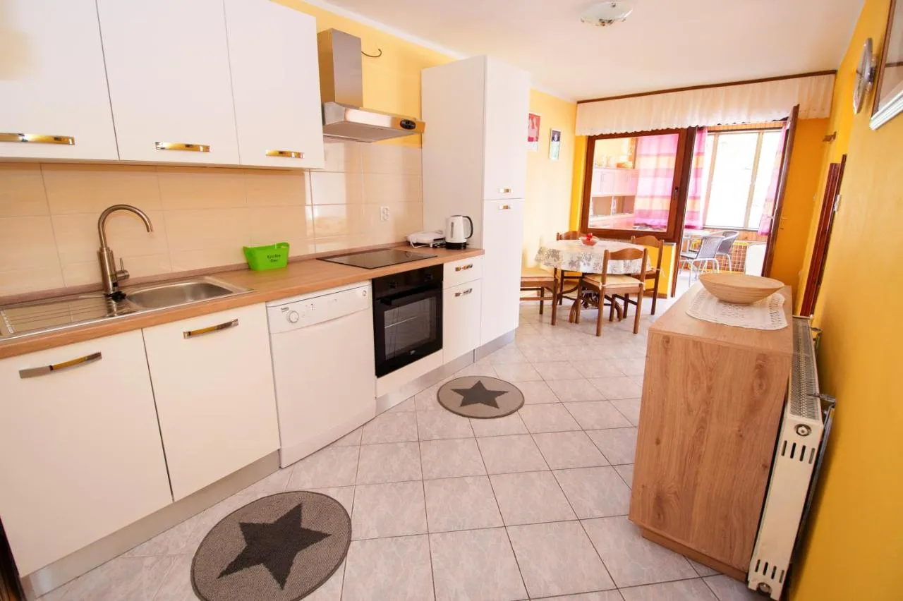 Svetla bela kuhinja z jedilnim kotom v apartmaju za 6