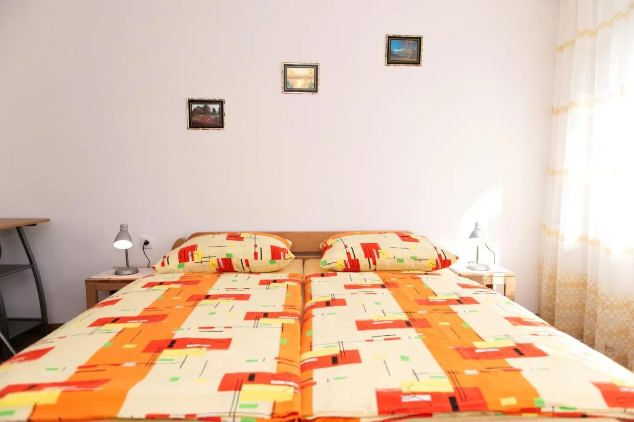 Spalnica z zakonsko posteljo in oranžnim pregrinjalom v apartmaju za 6