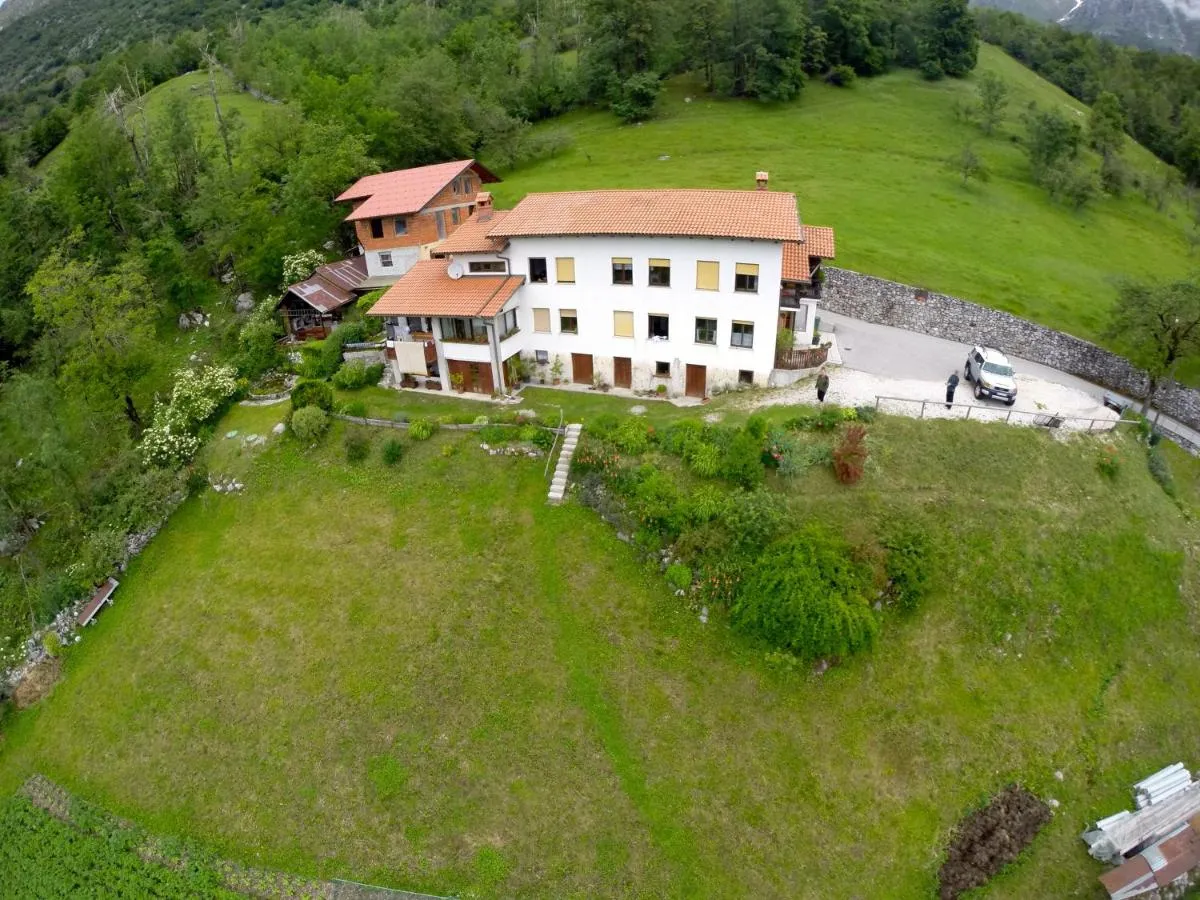 Hiša Berginc iz zraka, ob njej parkirišče in travnik